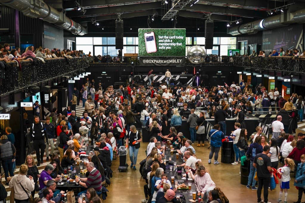 Busy indoor social venue at Boxpark Wembley with crowds and tables